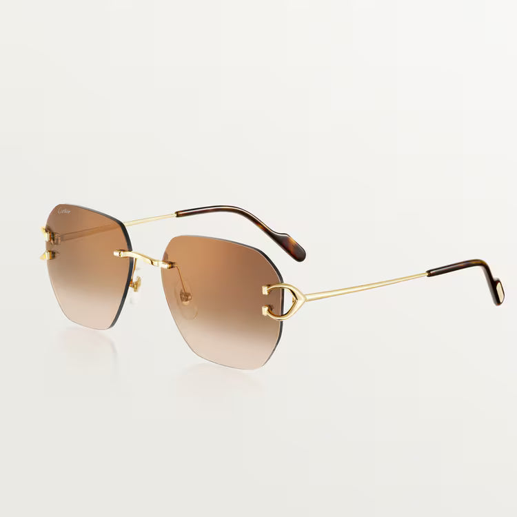 Sunglasses with gold frame and brown gradient lenses on a light gray background